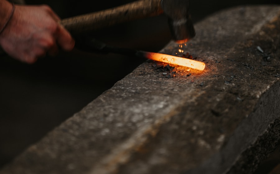 A metalworker holding hot metal in a forge flame